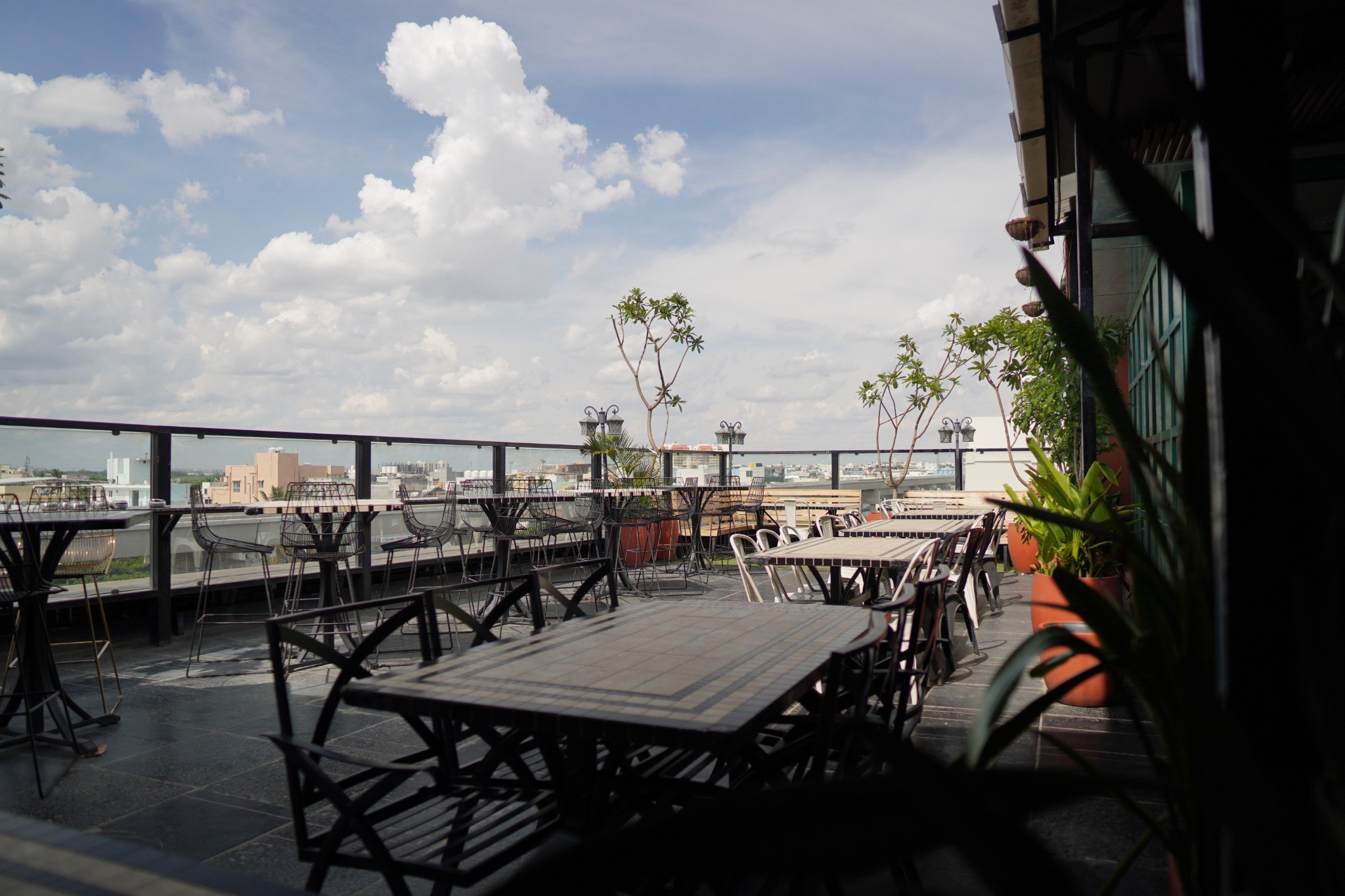 Don't Tell Mama rooftop with open sky, tables and the Bangalore skyline
